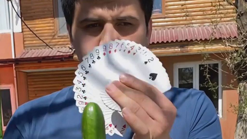 Nuriddin Karimov gets ready to split a cucumber in two with a playing card. (Nuriddin Karimov/Zenger News)