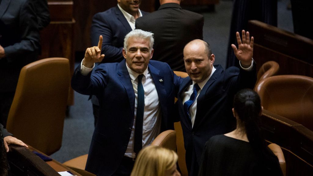 New Israeli Prime Minister Naftali Bennett, right, and Foreign Minister Yair Lapid, left, celebrate after the Knesset in Jerusalem voted to approve their new government on June 13. The new government, a broad coalition of parties with a razor-thin majority, ended the 12-year reign of Benjamin Netanyahu. (Amir Levy/Getty Images)