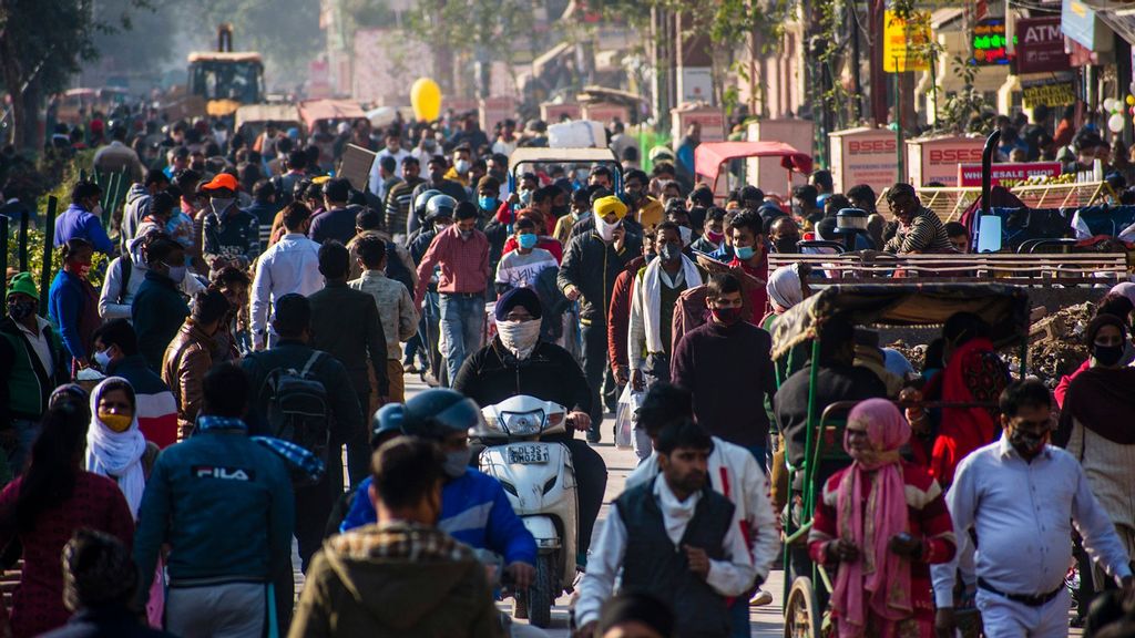 Crowds of Indians with and without protective face masks walk in a street, as India crossed 10 million Covid-19 cases, becoming the second nation in the world after the US to reach the grim milestone, in Delhi, India. (Yawar Nazir/Getty Images)