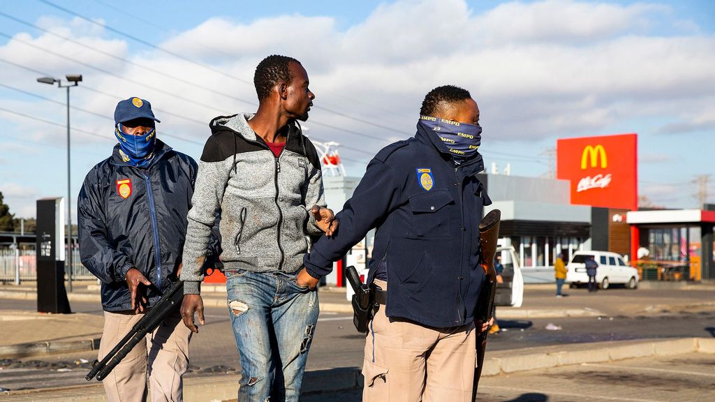 Police detain a man suspected of looting on July 13, 2021 at a shopping centre in Vosloorus, Johannesburg, South Africa. South Africa has deployed the military to quell spasms of civil unrest and looting sparked by last week's imprisonment of former president Jacob Zuma. The unrest is also fueled by high unemployment and social and economic fallout from the Covid-19 pandemic, which has hit the country hard. (James Oatway/Getty Images)