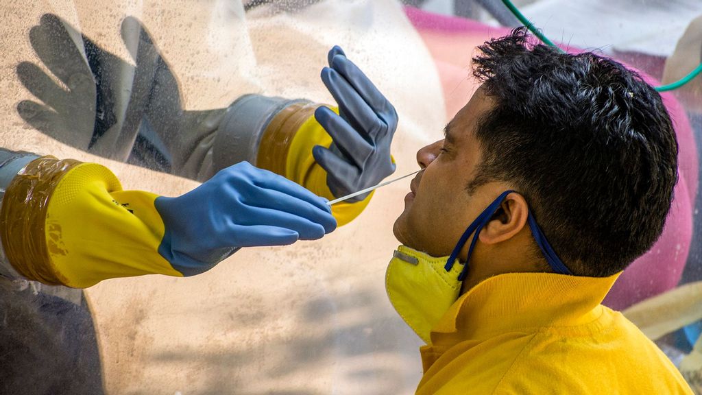 An Indian health official uses a nasal swab to collect a Covid-19 sample from a man, as India remains under an unprecedented extended lockdown over in New Delhi, India. (Yawar Nazir/Getty Images)