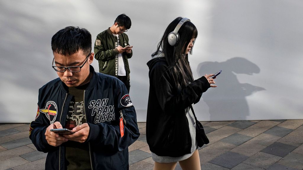 People look a their mobile phones at  a luxury mall on October 31, 2019 in Beijing, China. (Kevin Frayer/Getty Images)