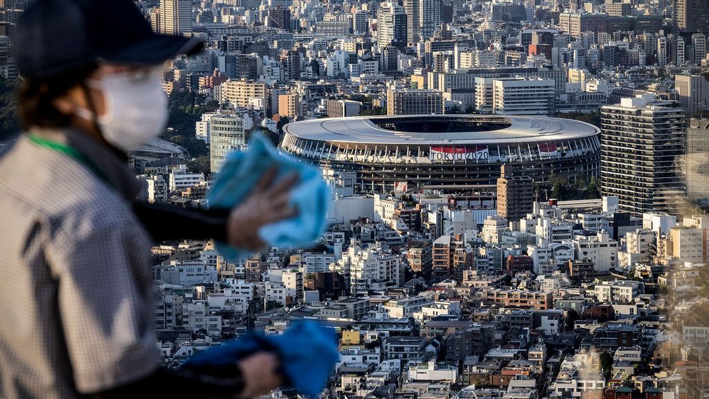 A cleaner wipes a window overlooking the Tokyo Olympic stadium on Shibuya Sky Deck on July 22, 2021 in Tokyo, Japan. Olympics opening ceremony director, Kentaro Kobayashi, has been sacked on the eve of the event after footage emerged in which he appeared to make jokes about the Holocaust. Mr Kobayashi follows a number of other figures involved in the Tokyo Olympic Games who have had to step down for inappropriate remarks. (Carl Court/Getty Images)