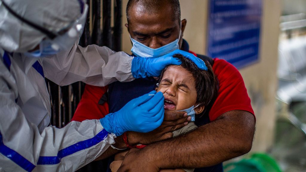 Indian health official uses a swab to collect sample from a child to conduct tests for the coronavirus disease (COVID-19), amid the spread of the disease, at Nehru Homoeopathic Medical College and Hospital, in New Delhi, India. (Yawar Nazir/Getty Images)