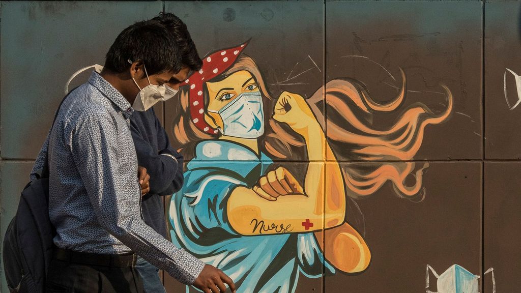 A man walks past a mural referring to the Covid-19 coronavirus painted on a wall in New Delhi, India. (Anindito Mukherjee/Getty Images)