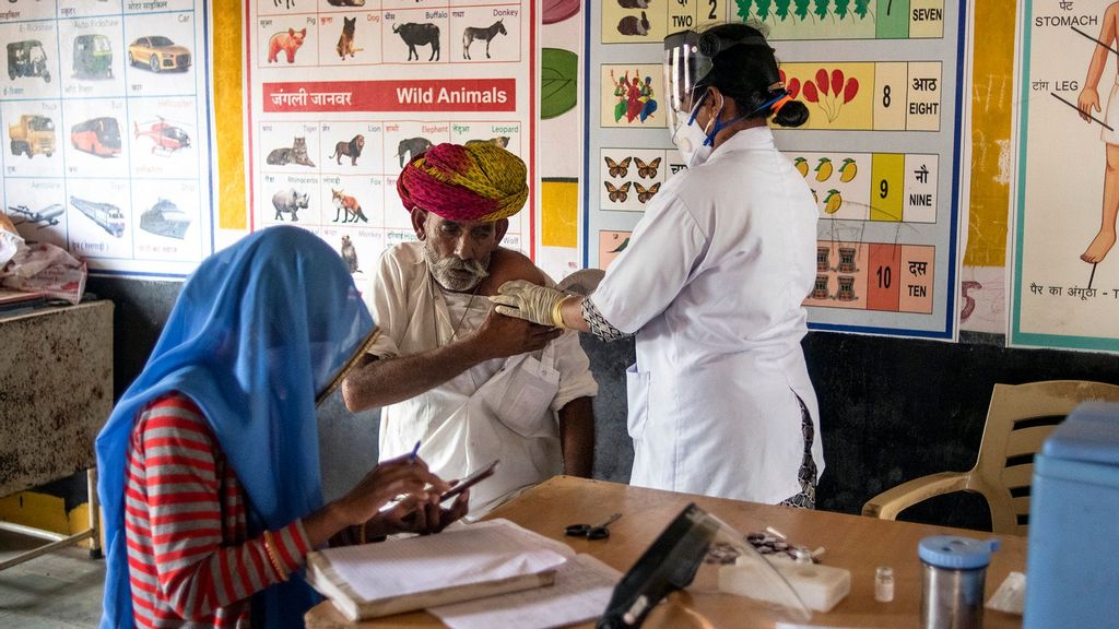 Indian auxiliary nurse Punnamma VS administers the Covaxin coronavirus vaccine during a vaccination clinic amid Rajasthan's ongoing coronavirus lockdown on May 17, 2021 in Aakhtadi, Tonk District, Rajasthan, India. (Rebecca Conway/Getty Images)