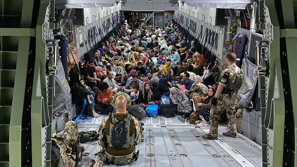 In this handout image provided by the Bundeswehr, evacuees from Kabul sit inside a military aircraft as they arrive at Tashkent Airport on August 22, 2021, in Tashkent, Uzbekistan. German Chancellor Merkel said Germany must urgently evacuate up to 10,000 people from Afghanistan for which it is responsible. (Image Handout by Bundeswehr/Getty Images)