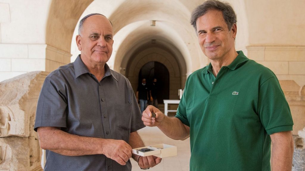 IAA Director Eli Eskosido (left) presents Israeli astronaut Eytan Stibbe with an ancient coin for guardianship while on his trip to space. (Yoli Schwartz/IAA)