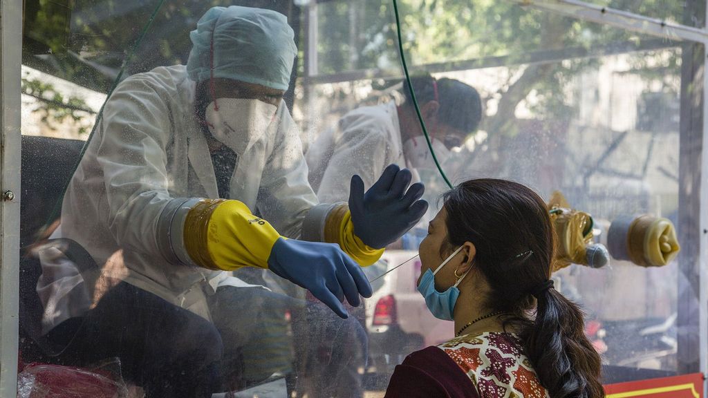 An Indian health official inside a COVID-19 mobile testing van uses a nasal swab to collect a sample from a woman, as India remains under an unprecedented extended lockdown over the highly contagious coronavirus (COVID-19) in New Delhi, India. (Yawar Nazir/Getty Images)