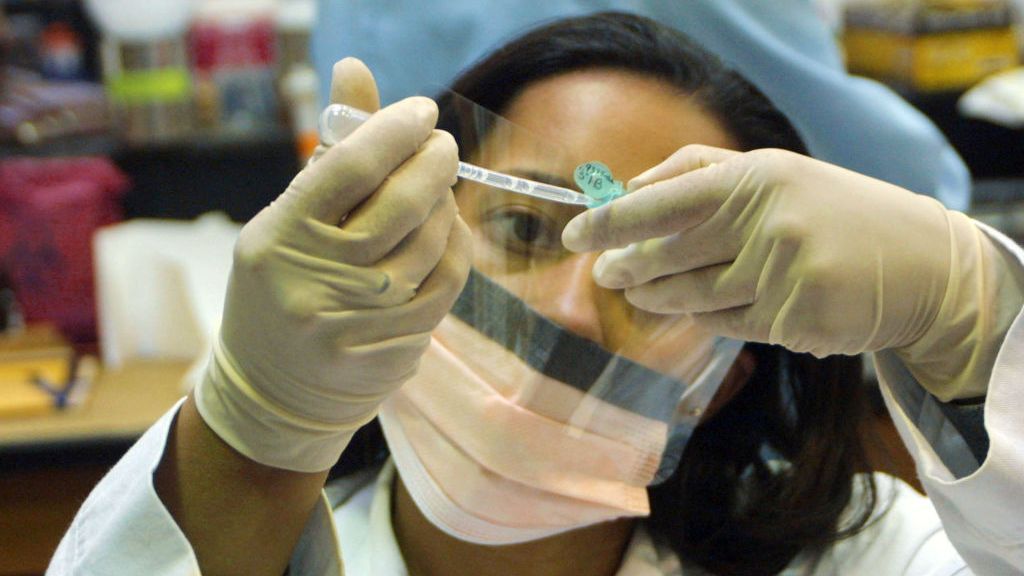 A forensic scientist prepares blood samples for DNA extraction for evidence in a sexual assault case in the Forensic Evidence section of the Louisiana State Crime Lab June 4, 2003 in Baton Rouge, Louisiana. A new study has revealed that DNA can be left on surfaces without ever touching them, complicating forensic investigation and underscoring the need to avoid cross-contamination in the lab. (Mario Villafuerte/Getty Images)