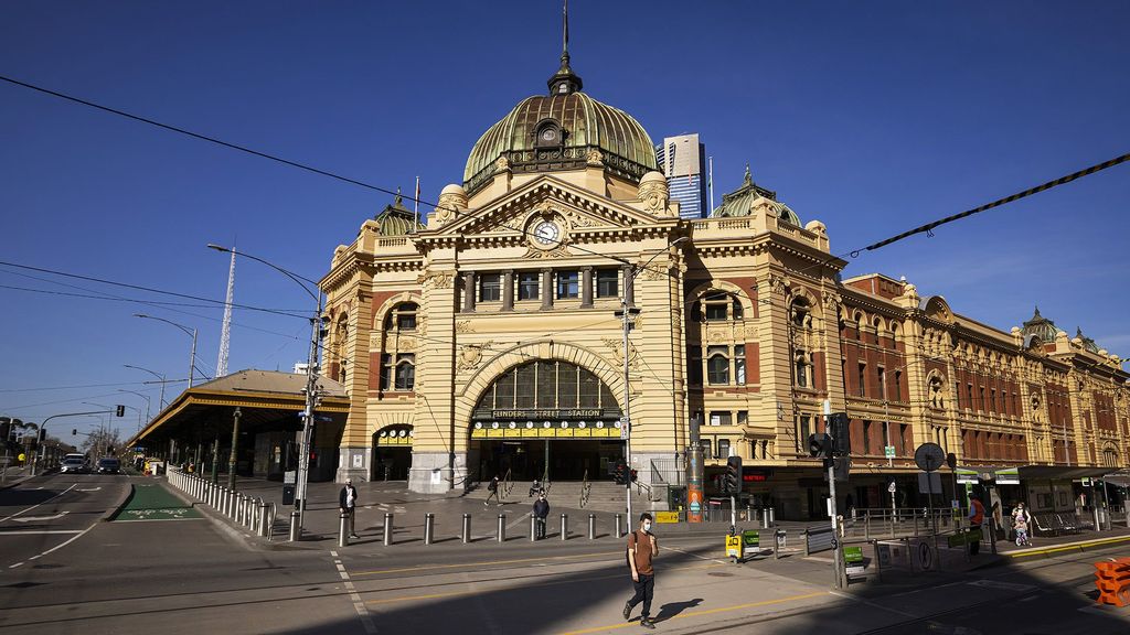 People are seen crossing a quiet Flinders Street on September 01, 2021 in Melbourne, Australia. Lockdown restrictions are currently in place across Melbourne as Victoria continues to record new cases of the highly infectious COVID-19 Delta variant, including a curfew from 9 pm to 5 am each night across the metropolitan area. (Daniel Pockett/Getty Images)